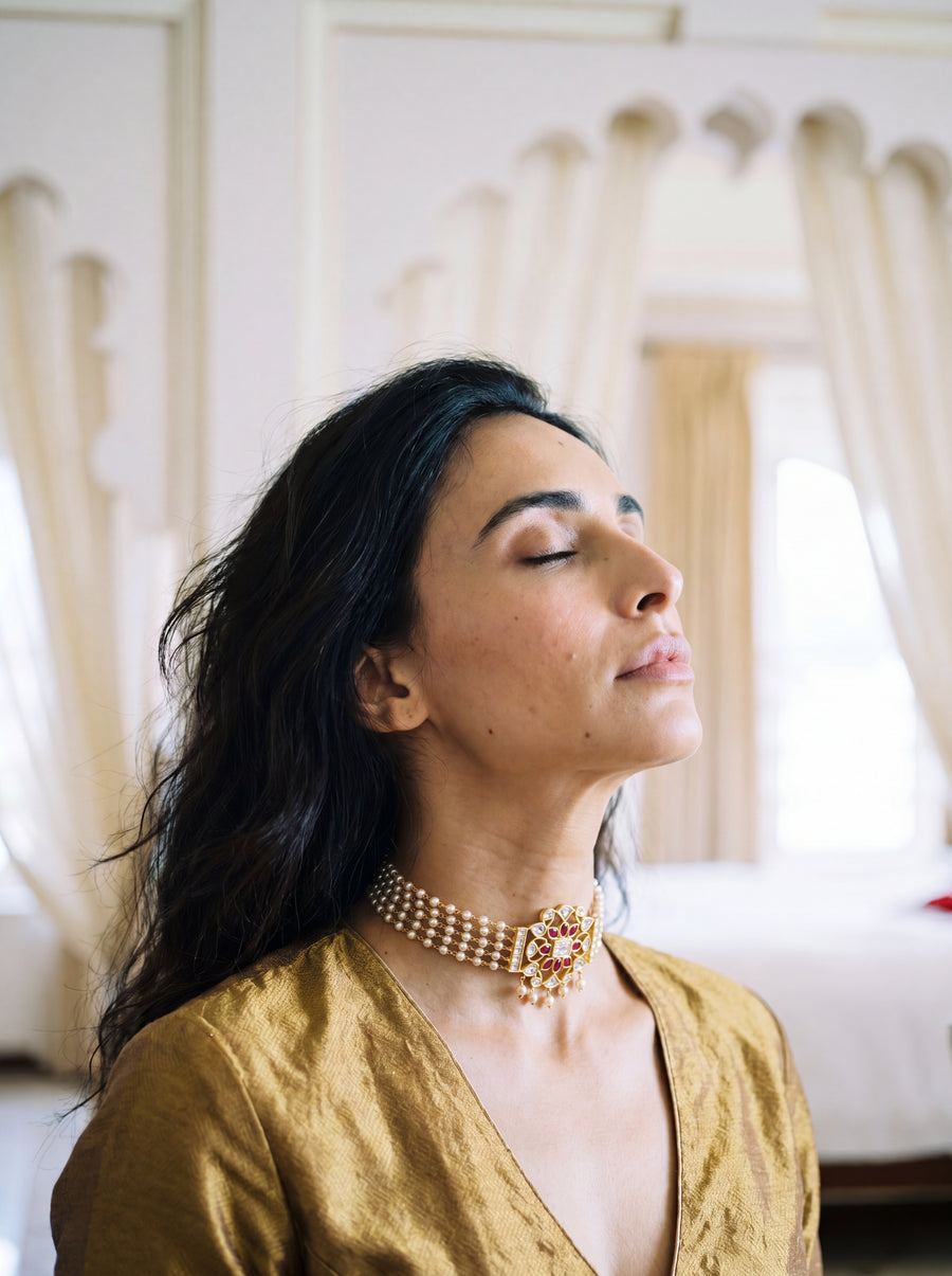 Jadau Kundan pearl choker with a four-strand pearl chain and ruby-kundan pendant
