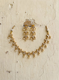 Jadau Kundan necklace with a leaf-motif vine and matching drop earrings