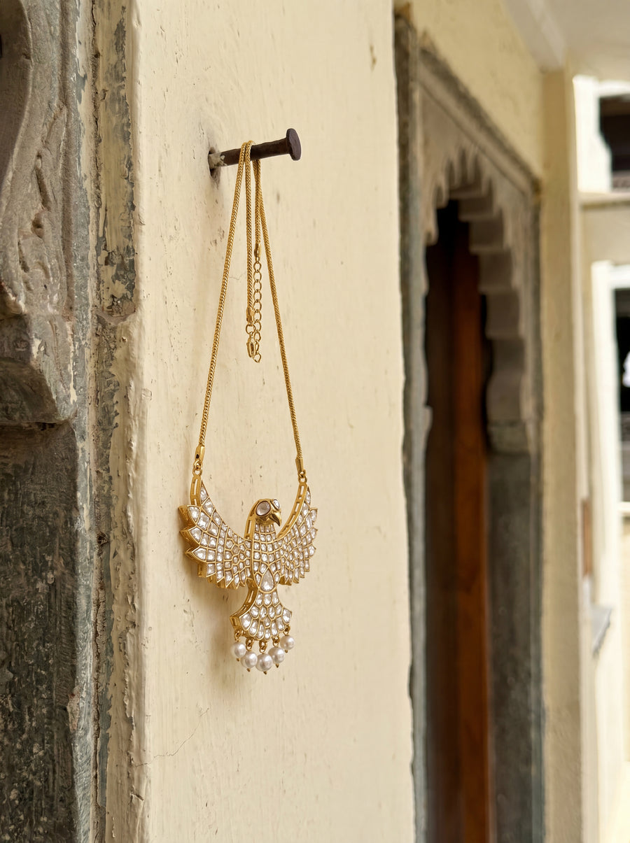Kundan falcon pendant with full stone coverage and pearl-drop tail feathers