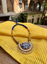 Blue meenakari wing pendant with Kundan border and pearl drops on a wrapped dori