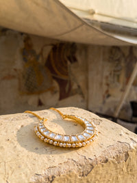 Kundan Polki crescent pendant with a seed-pearl border on a gold curb chain