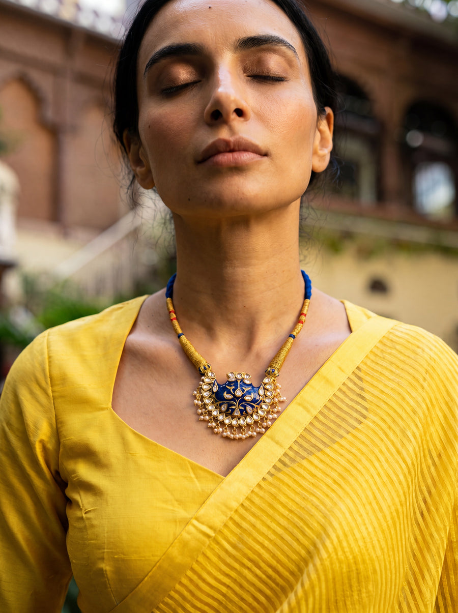 Blue meenakari wing pendant with Kundan border and pearl drops on a wrapped dori