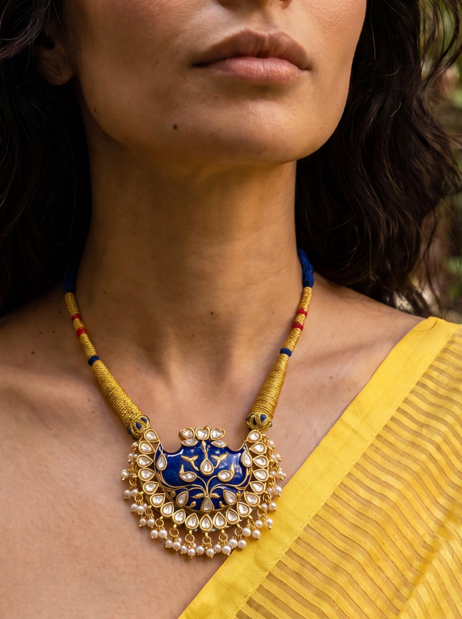 Blue meenakari wing pendant with Kundan border and pearl drops on a wrapped dori