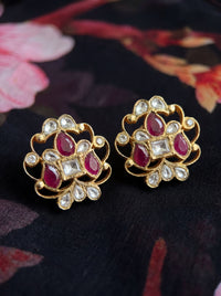Kundan stud earrings with an open filigree scroll and deep ruby cluster