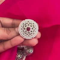 925 silver rakhdi with a ruby-centred CZ pave floral disc and double pearl border