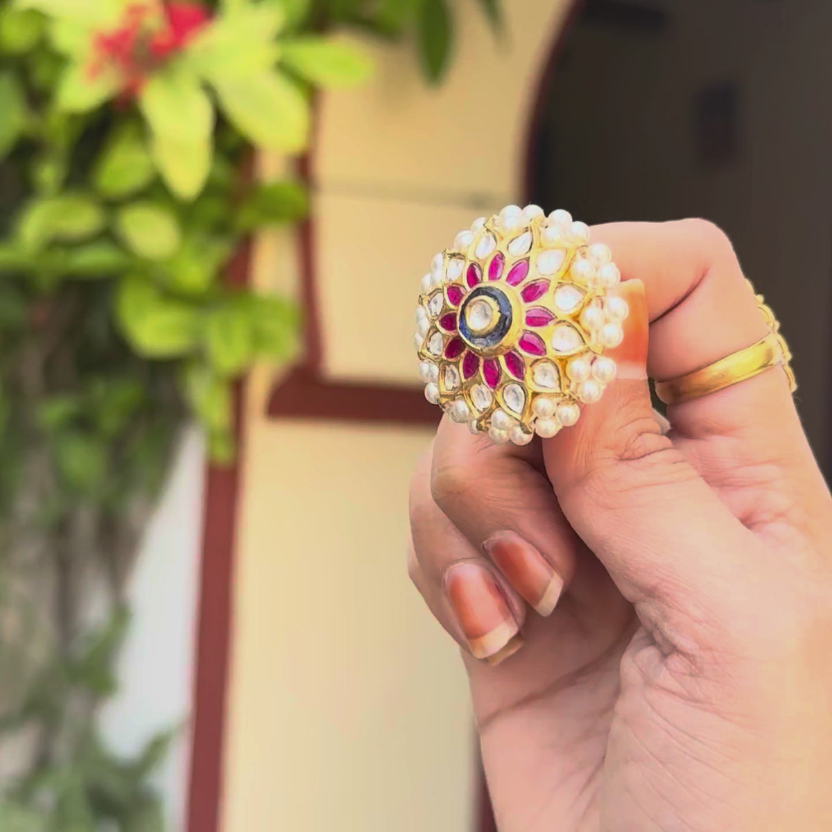 925 silver rakhdi with ruby meenakari petals and a sapphire kundan centre