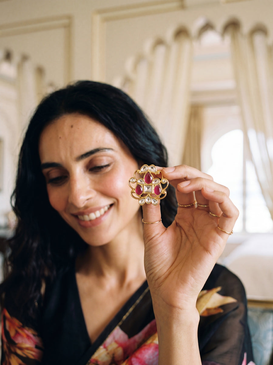 Kundan stud earrings with an open filigree scroll and deep ruby cluster
