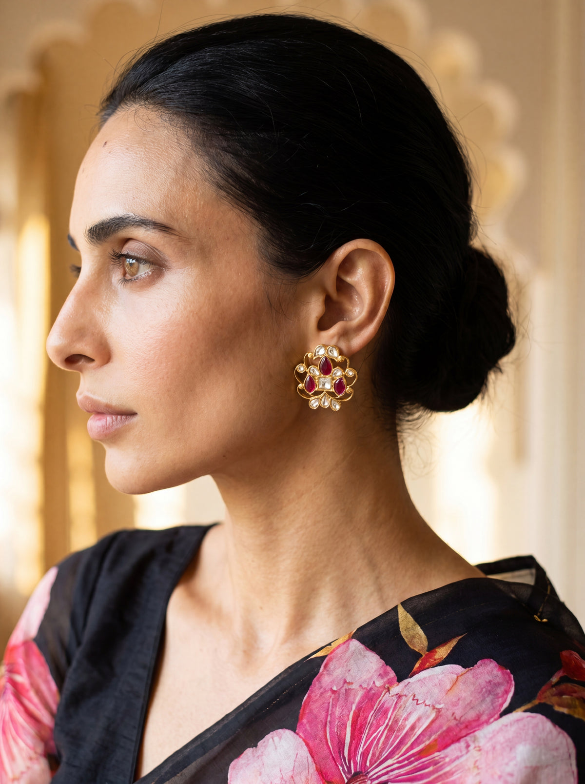 Kundan stud earrings with an open filigree scroll and deep ruby cluster