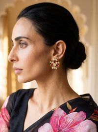 Kundan stud earrings with an open filigree scroll and deep ruby cluster