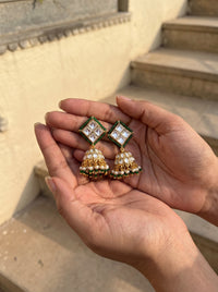 Kundan jhumka earrings with an emerald bead border and pearl-green fringe