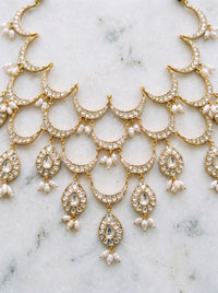 Kundan Polki bib necklace with cascading wave motifs and pearl drop clusters